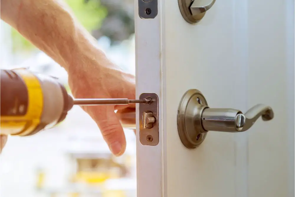 close-up woodworker hands install lock.