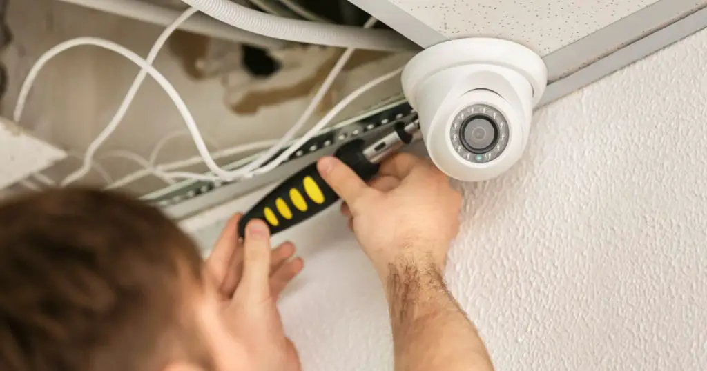 Electrician Installing Security Camera Indoors