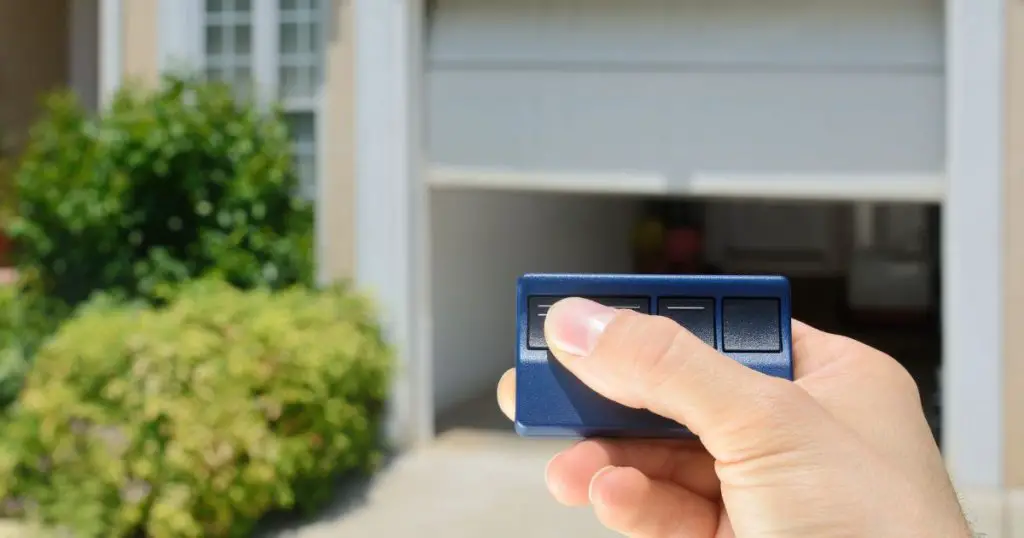 garage door and man's hand holding remote contoller 